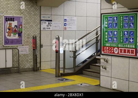 Posters a Tokyo Metro Station durante l'epidemia di coronavirus: Uno chiede ai passeggeri di indossare maschere, l'altro un annuncio centro pachinko con le sue misure di sicurezza. Foto Stock