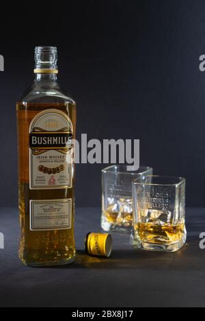 Bushmills whiskey con due bicchieri su sfondo scuro Foto Stock