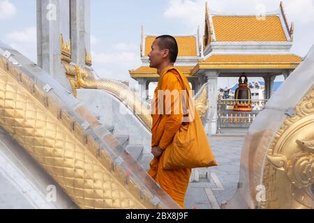 Monaco buddista che cammina sulle scale del Wat Traimit, il Tempio del Buddha d'oro, Chinatown, Bangkok, Thailandia, Sud-Est asiatico. Foto Stock