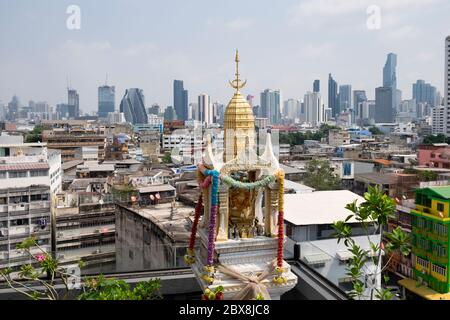 Piccolo tempio buddista con terrazza sul tetto con lo skyline della zona Silom sullo sfondo. Bangkok, Thailandia, Sud-Est asiatico. Foto Stock