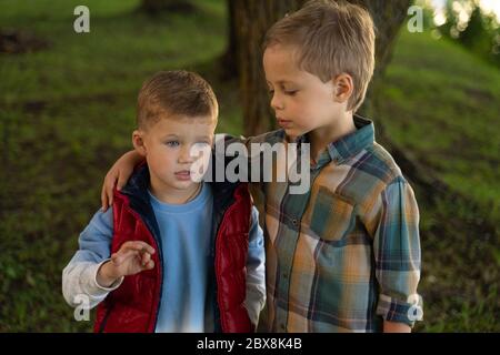 Ritratto di due ragazzi, fratelli e migliori amici sorridenti. Amici che abbracciano. Foto Stock