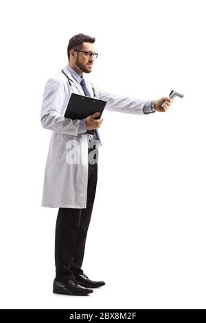 Immagine a profilo intero di un medico maschio che misura la temperatura con un termometro distante isolato su sfondo bianco Foto Stock