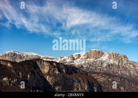 Vetta della Paganella o cima Roda (2125 m), Alpi innevate con le antenne della stazione meteo, vista dalla città di Trento, Trentino, Italia. Foto Stock