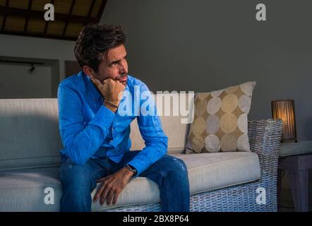 ritratto di stile di vita di giovane attraente e bello triste uomo latino seduta stanco e depresso a casa divano divano sensazione sopraffatta e preoccupato suffe Foto Stock