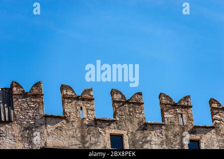 Castello del Buonconsiglio o Castello medievale di Castelvecchio nella città di Trento. Closeup di merellazioni con le fessure freccia o scappatoia. Trentino. Foto Stock