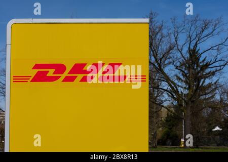 Logo DHL sul lato di una stazione di imballaggio dove i clienti possono ritirare il loro ordine e anche inviare i pacchi Foto Stock