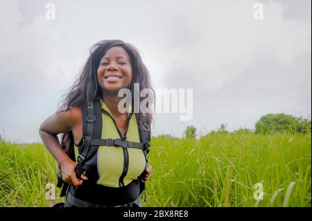 Giovane bella e felice nera afro americano turista zaino in spalla donna trasporto zaino in viaggio esplorando giungla e campi di riso in Thailandia o Vietna Foto Stock