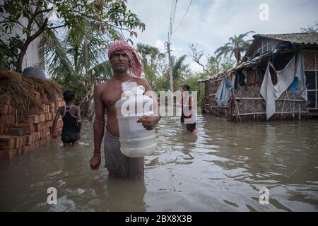 Basirat, India. 05 giugno 2020. Un uomo cammina attraverso una zona allagata per recuperare acqua potabile per la sua famiglia. La popolazione di tutto il villaggio costiero è ancora oggi vittima di crisi dell'acqua potabile dopo due settimane di alluvione causata dal super ciclone Amphan. (Foto di JIT Chattopadhyay/Pacific Press) Credit: Pacific Press Agency/Alamy Live News Foto Stock