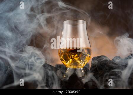 Un vetro Whisky Glencairn seduto sul carbone Foto Stock