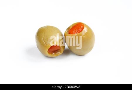 Due olive verdi farcite con pepe rosso. Olive piene umide isolate Foto Stock