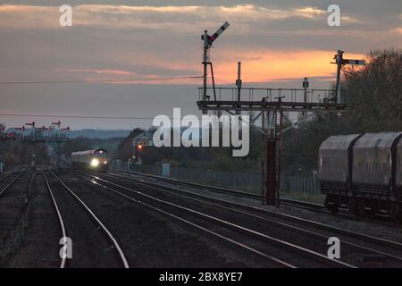 GB Railroad classe 66 locomotiva 66715 che si avvicina al semaforo a Barnetby con un treno merci al crepuscolo Foto Stock