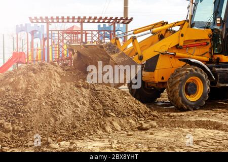 Escavatore alla luce solare. Macchina Digger scavare e rimuovere terra regolare il livello del terreno in cantiere Foto Stock
