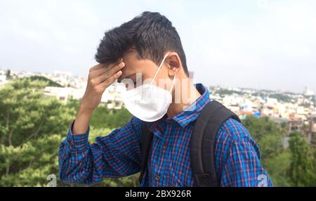 Un giovane studente maschio teen che indossa la maschera facciale e preoccupato per la crisi epidemica di salute. Foto Stock