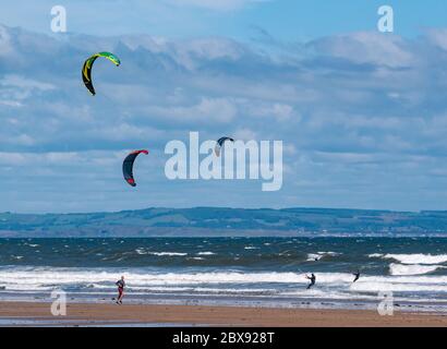 Firth of Forth, Scozia, Regno Unito, 6 giugno 2020. UK Weather: Un gruppo di kite surfers ritorno al mare dopo il blocco di allentamento permette alcuni sport all'aperto. Dopo un inizio noioso in una giornata tempesta il sole è uscito per creare le giuste condizioni a Broadsands Bay Foto Stock