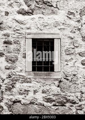 Vecchia prigione con finestra di prigione con barre di metallo arrugginito. Immagine di stile vintage. Foto Stock