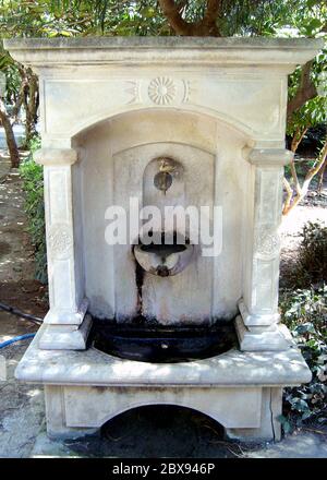 Vecchia fontana nel giardino di Creta, Grecia, con acqua potabile. Foto Stock