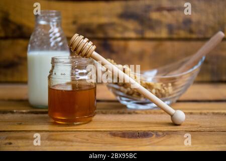 Composizione con latte, noci e miele su fondo ligneo Foto Stock