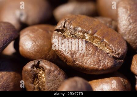 Caffè marrone arrosto fagioli primo piano macro foto cibo naturale sfondo, fuoco selettivo, profondità di campo poco profonda. Foto Stock