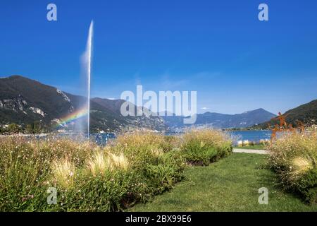 Paratico e Sarnico sul Lago d'Iseo. Passeggiata della città. Paesaggio del lago con installazioni d'arte di giardinaggio e fontana a getto. Paratico (BS), IT Foto Stock