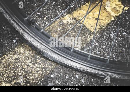 Vista in primo piano della ruota piatta della bicicletta sul marciapiede. Bicicletta con pneumatico a terra. Bicicletta con pneumatico sgonfio. Foto Stock