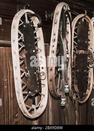 Racchette da neve in legno d'epoca appese al muro in un cottage di montagna. Foto Stock