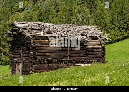 Primo piano di un antico fienile in legno con tetto rotto in montagna, Val di Fiemme, Bellamonte villaggio, Predazzo, Trentino Alto Adige, Italia, Europa Foto Stock