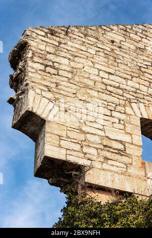 Primo piano di una vecchia rovina di una parete fortificata austriaca fatta di blocchi di pietra su cielo blu con nuvole. Provincia di Verona, Italia, Europa Foto Stock