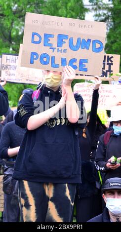 Un manifestante porta un cartello 'fondo di polizia' in una protesta contro la questione Black Lives nel centro di Manchester, Inghilterra, Regno Unito, il 6 giugno 2020, alla quale hanno partecipato molte migliaia di manifestanti, in solidarietà con i manifestanti negli Stati Uniti in merito alla morte di George Floyd. Floyd, un uomo afro-americano, è morto a Minneapolis, Minnesota, Stati Uniti, il 25 maggio 2020, mentre è stato arrestato da 4 agenti di polizia dopo che un assistente del negozio ha asserito di aver cercato di pagare con un disegno di legge contraffatto di 20 dollari. Foto Stock