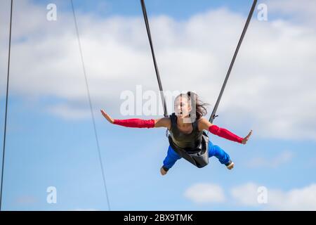 San Giovanni, New Brunswick, Canada - 4 settembre 2015: un acrobat suona alla mostra di San Giovanni. È tenuta in su dai cavi fissati a lei. Foto Stock