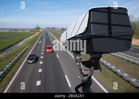 La telecamera TVCC di sicurezza o il sistema di sorveglianza osservano il traffico veicolare su una strada con sfocatura intenzionale sullo sfondo Foto Stock