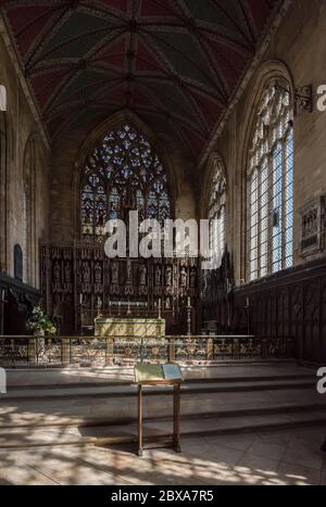 Interno di alto alter nella chiesa di St. Botolph a Boston, Lincolnshire con luce solare che scorre attraverso le finestre che gettano ombre modellate sul pavimento. Foto Stock