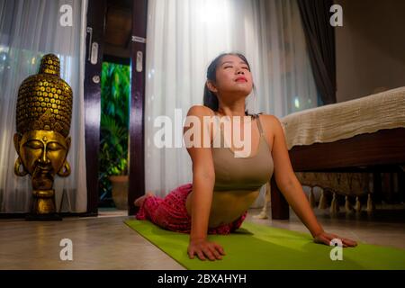 yoga contro lo stress di quarantena lockdown - giovane bella e felice coreana asiatica donna facendo yoga allenamento a casa camera da letto praticando relax e me Foto Stock