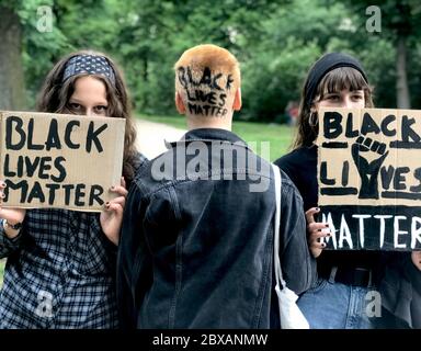 Berlino, Germania. 06 giugno 2020. 'Black Lives Matter' è scritto sulla parte posteriore della testa di una giovane donna. Altri due manifestanti tengono in mano i poster con lo stesso slogan. Protestano contro il razzismo e la violenza della polizia nel Volkspark Friedrichshain. L'occasione è la morte del afroamericano George Floyd a seguito di un'operazione di polizia negli Stati Uniti. Credit: Annette Riedl/dpa/Alamy Live News Foto Stock