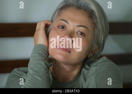 crisi di signora matura - ritratto di stile di vita interno di donna di mezza età con capelli grigi triste e depresso nel letto sensazione di frustrazione e solitario pensiero ab Foto Stock