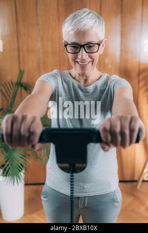 Donna anziana che misura la composizione del corpo con scala digitale Foto Stock