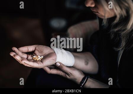 Donna travagliata con pillole in mano Foto Stock