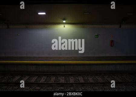 Piattaforma ferroviaria vuota. Vista frontale scura. Stazione della metropolitana senza passeggeri. Senza meta e senza meta. Foto Stock