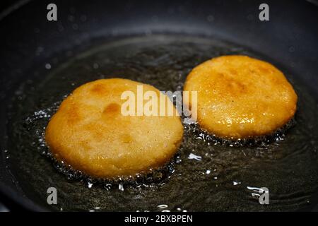 Arepas in una padella con olio. Primo piano. Foto Stock