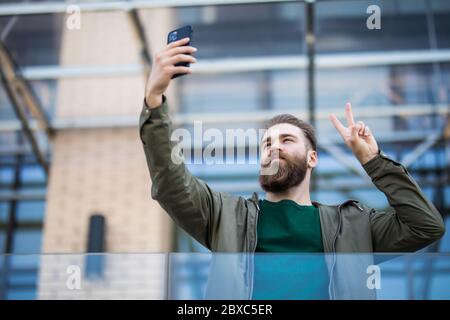 Chattare e incontrare gli amici online. Bearded man chattare online via cellulare. Riunione online. Conferenze audio o video su dispositivo mobile. Online Foto Stock