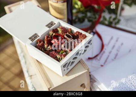 Due anelli di nozze d'oro in un bel casket di legno con muschio verde. Accessori per matrimoni. Mattina sposa Foto Stock