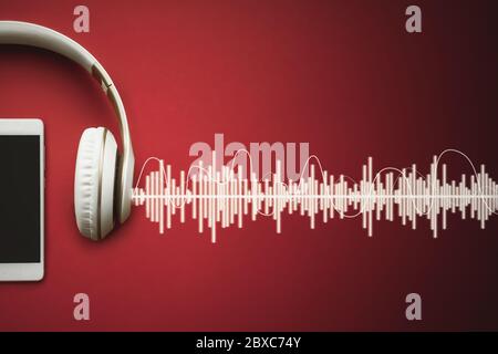 Moderno cellulare Bianco modello e cuffie su sfondo rosso gradiente con traccia Audio. Concetto musicale Foto Stock