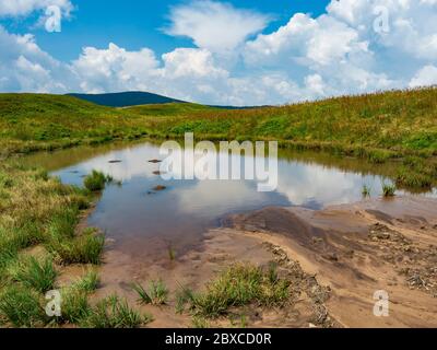 Piccolo stagno sulla cima della montagna con nuvole che si riflettono sull'acqua. Cresta di Borzhava, Ucraina Foto Stock