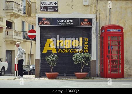 Il salone di parrucchiere Angel all'angolo, con un residente locale e una cabina telefonica reale rossa. Il parrucchiere chiuso si trova nel mezzo Foto Stock