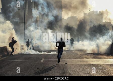 Beirut, Libano. 6 Giugno 2020. I manifestanti corrono per gettare di nuovo gas lacrimogeni alla polizia cercando di spingerli sull'autostrada Charles Helou dopo una protesta pacifica, violenta e i manifestanti si scontrarono tra loro, l'esercito e la polizia. Credit: Elizabeth Fitt/Alamy Live News Foto Stock