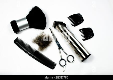 Un set di strumenti per tagliare e rifinire i capelli con un paio di forbici, un pettine, una spazzola e un mucchio di capelli - cura dei capelli domestici del coronavirus. Foto Stock