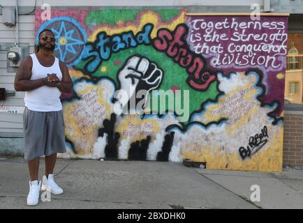 Racine, Wisconsin, Stati Uniti. 6 Giugno 2020. Rodney Bell è stato spostato per dipingere un murale sul lato di un edificio accanto al suo appartamento a Racine, Wisconsin Sabato sera 6 giugno 2020. Egli dice che dipinse il murale, che contiene il nome degli uomini uccisi dalla polizia nazionale e nella zona di Racine, per riunire le persone sia al tempo della pandemia di Coronavirus che dopo la morte di George Floyd mentre si trovava nella custodia della polizia a Minneapolis. Credit: Mark Hertzberg/ZUMA Wire/Alamy Live News Foto Stock