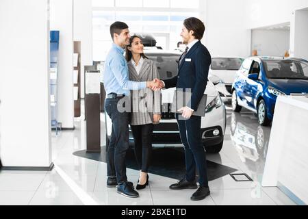 Manager Handshaking con i giovani acquirenti dopo aver avuto successo l'affare Foto Stock