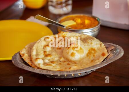 Cappati in stile indiano in un piatto sul tavolo con una ciotola di curry. Foto Stock