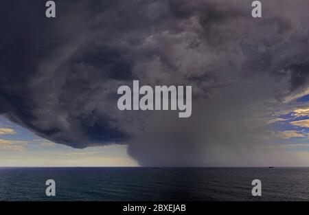 off shore rio grande 32.16 s 051.54 w, brasile - 2014.02.02: un'enorme nube di cumulonimbus che si sviluppa sopra l'oceano atlantico meridionale che precede una distanza Foto Stock