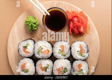 Set di sushi servito su tappeto di bambù e tavola di legno. Panini, wasabi e zenzero su uno sfondo chiaro Foto Stock